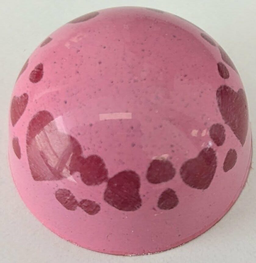 Raspberry yuzu (pate-de-fruit) in a white chocolate shell.